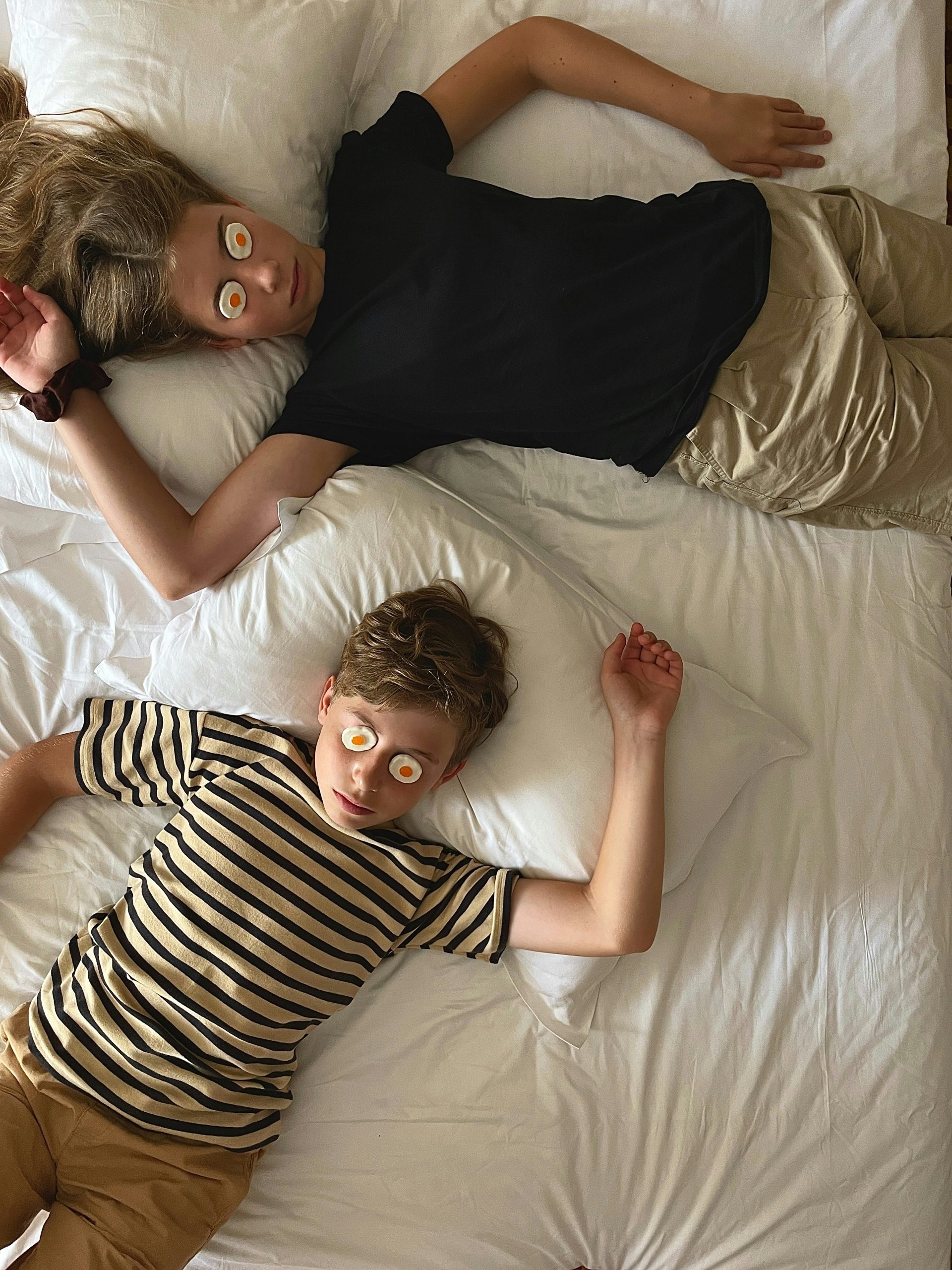 A couple of kids laying on top of a bed
