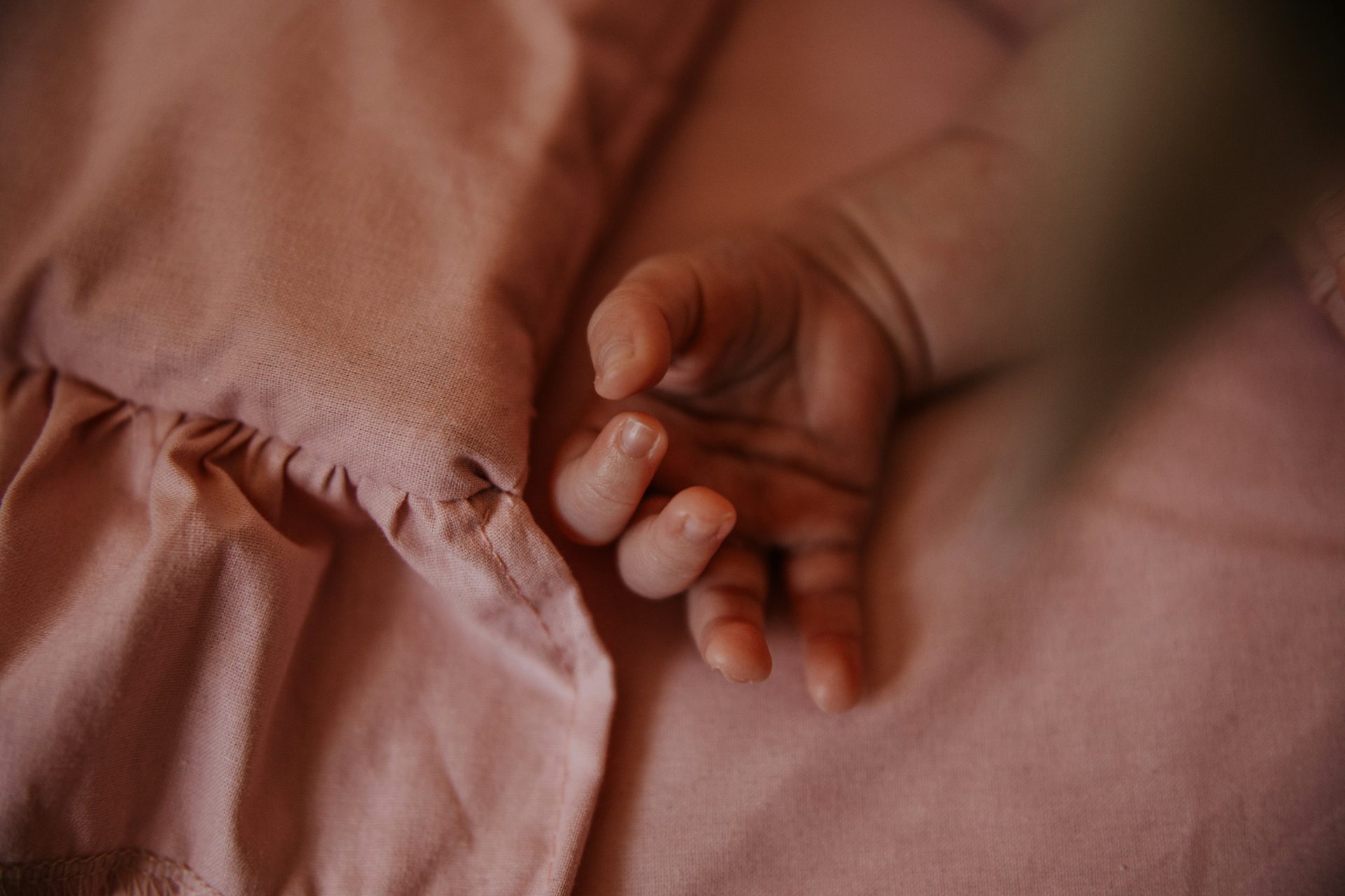 a close up of a person holding a baby's hand